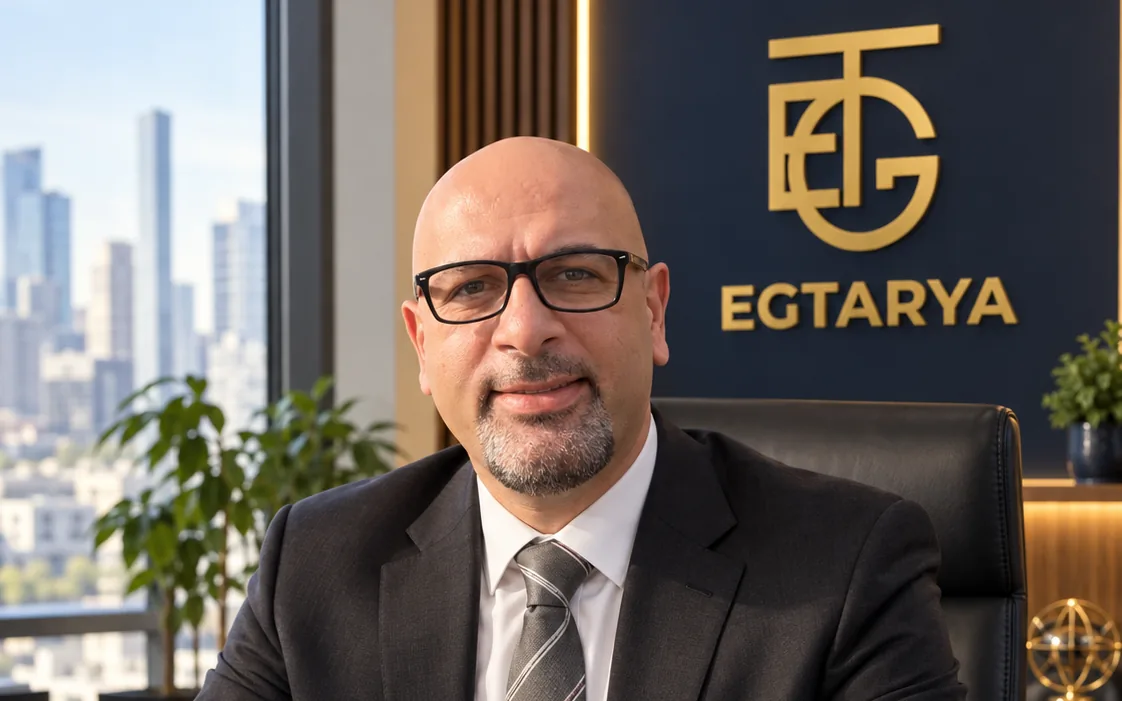 Mehdi Eghtedari, founder of EGTarya, at his desk with the EGT monogram behind him